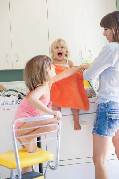 Mother and daughters in utility room