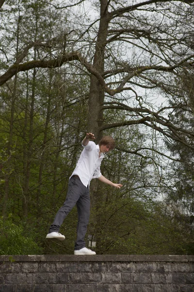 Młody Człowiek Białej Koszuli Dżinsach Pozujących Tle Drzew — Zdjęcie stockowe
