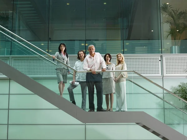 Five office workers standing on stairs