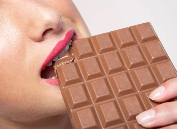 Frau Beißt Riesige Tafel Schokolade Stockfoto