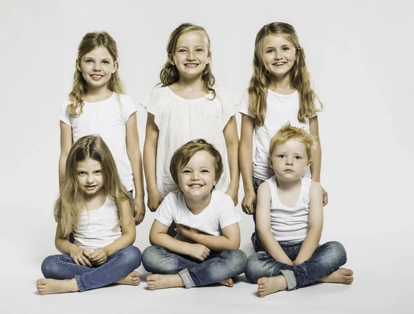 Retrato Estudio Cuatro Niñas Dos Niños Sentados Con Las Piernas —  Fotos de Stock