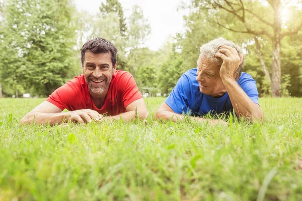 Двое Мужчин Отдыхают Траве После Упражнений — стоковое фото