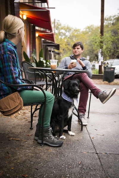 Couple with dog having coffee at sidewalk cafe, Savannah, Georgia, USA