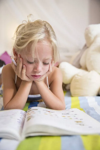 Mädchen Liegt Auf Dem Bett Und Schaut Auf Puzzle Buch — Stockfoto