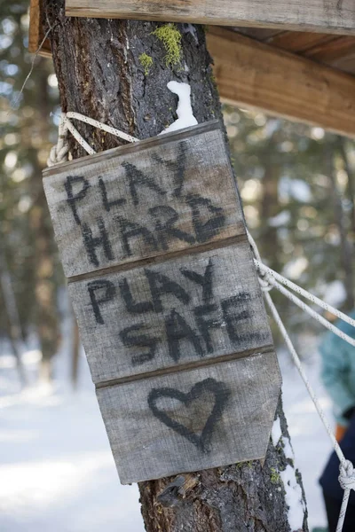 \'Play hard, play safe\' sign on tree