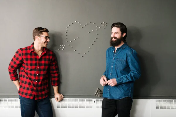 Two men by wall with heart shape