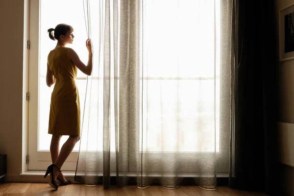 Frau Blickt Auf Ein Fenster — Stockfoto