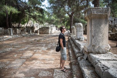 Man looking at ruins at Phaselis, Lycian way, Turkey clipart
