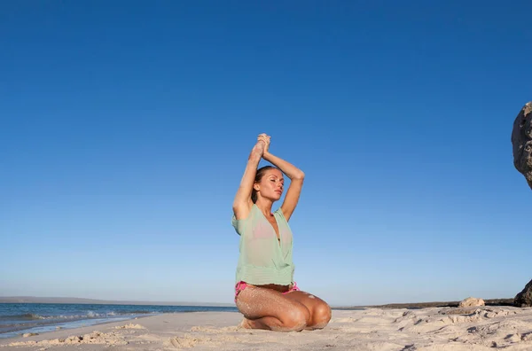 女性でビキニひざまずいてオンビーチ — ストック写真
