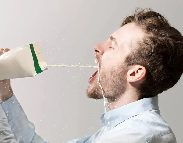Ung Man Spiller Mjölk Från Kartong Studio Skott — Stockfoto