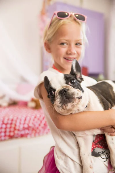 女の子運ぶかわいい犬でベッドルーム — ストック写真
