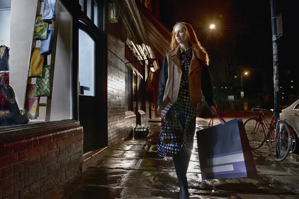 Front View Young Woman Walking Street Carrying Shopping Bag Βράδυ — Φωτογραφία Αρχείου