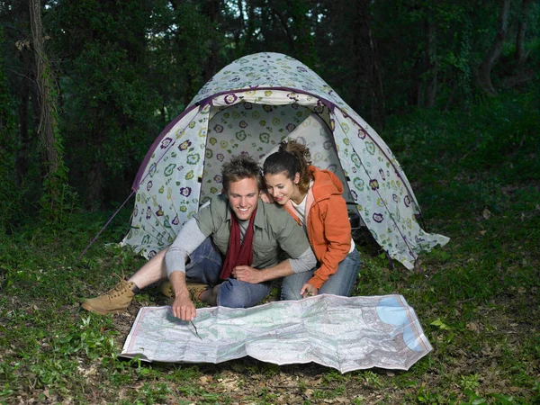 Couple reading map in front of tent