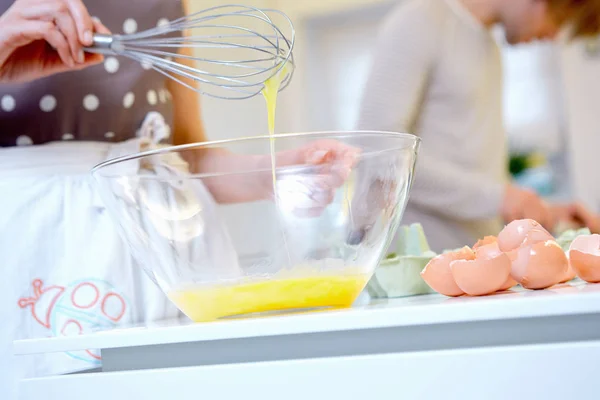 Woman whisking eggs in mixing bowl