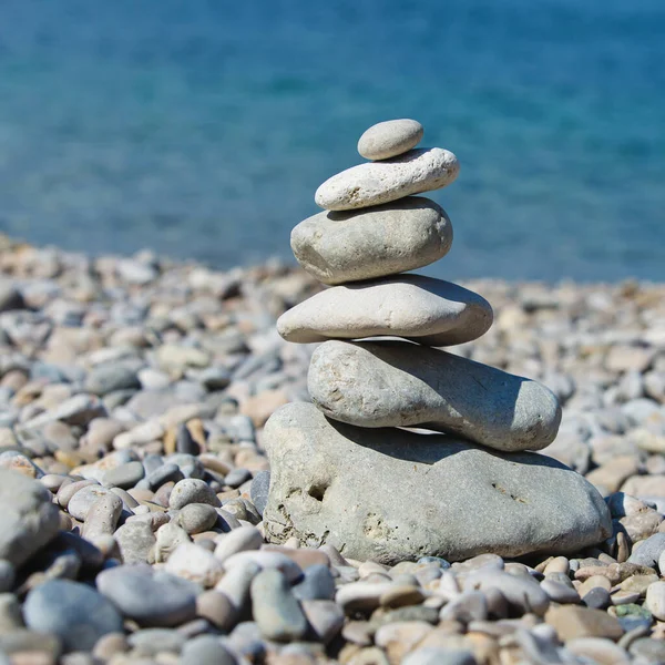 Stone Pyramide Standing Pebble Beach Blue Sea Background Square Composition — Stock Photo, Image