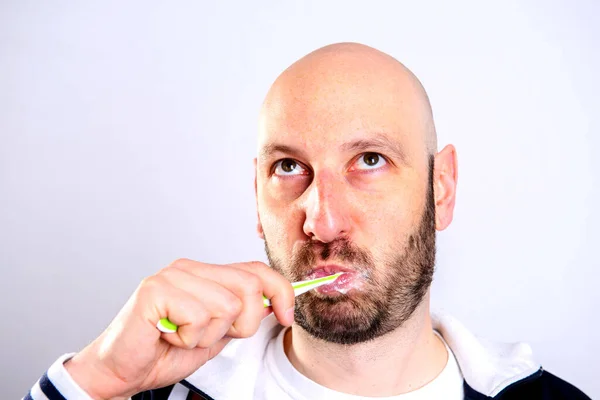 Φαλακρός Άνθρωπος Που Βουρτσίζει Δόντια Μπροστά Από Γκρι Φόντο — Φωτογραφία Αρχείου