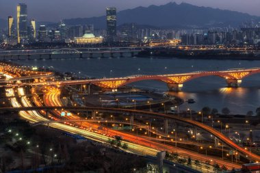 The night view of Seongsan bridge over the han river and Yeouido with the national assembly building. Viewed from Haneul park in seoul, south korea clipart