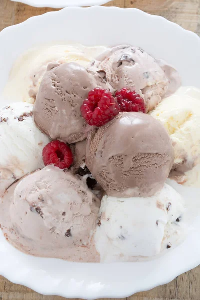 ラズベリーとホワイトプレートにチョコレートアイスクリームのスクープ — ストック写真
