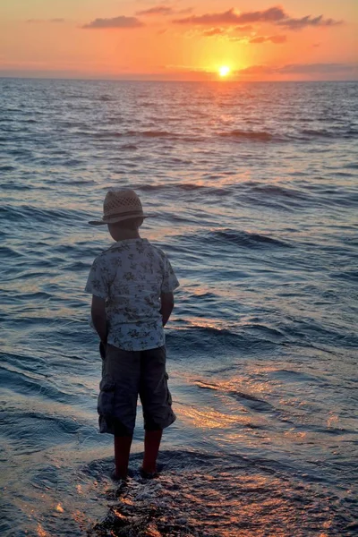 Küçük Çocuk Gün Batımında Dalgaların Arasında Duruyor Elleri Ceplerinde Suya — Stok fotoğraf