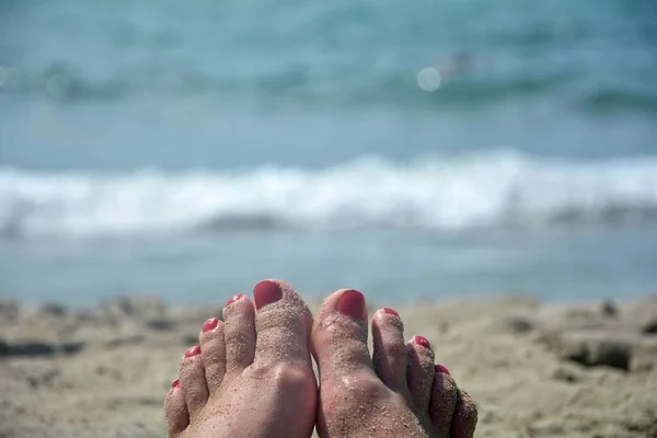 砂浜に赤い歯があり背景に青い海が見える — ストック写真