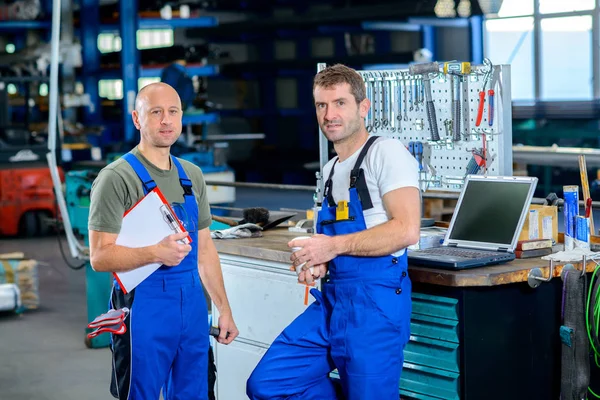 two worker in factory on work bench