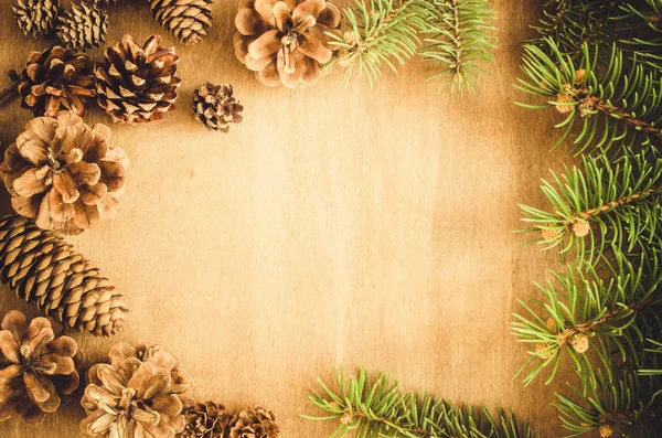 圣诞背景 在一个带有仿制空间的乡村木桌上的框架中的锥形和分枝冷杉树 顶部视图 复制空间 有选择的重点 被投掷的图像 — 图库照片