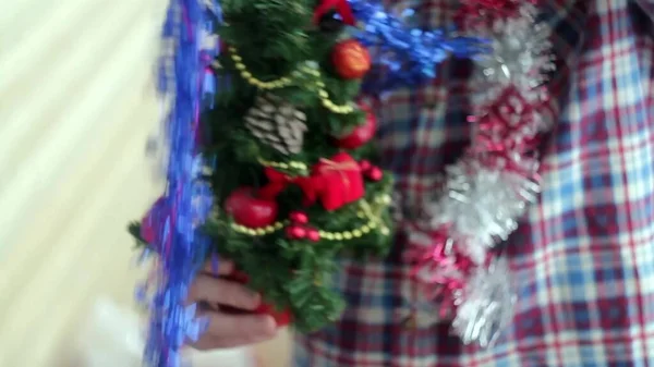 一个年轻人穿着漂亮的闪闪发光的小圣诞树 — 图库照片
