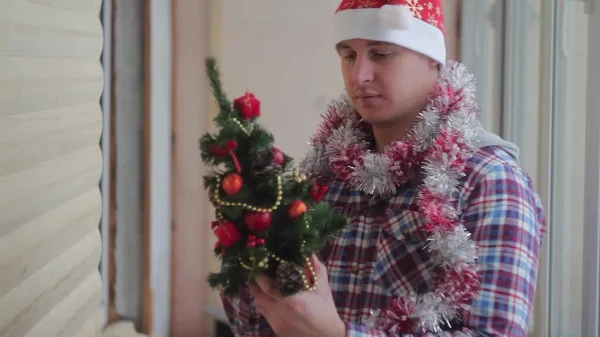 Young Man Dresses Beautiful Little Glowing Christmas Tree — Stock Photo, Image