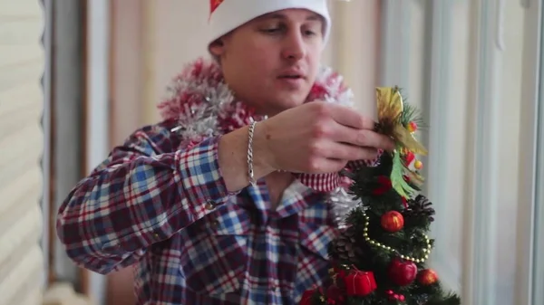 Young Man Dresses Beautiful Little Glowing Christmas Tree — Stock Photo, Image