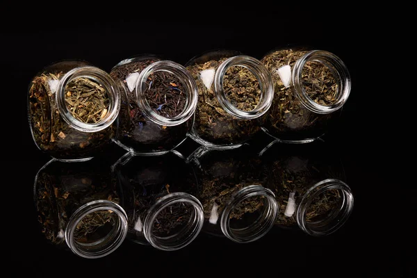 Różne Rodzaje Suchej Herbaty Szklanych Słoikach Stojących Czarnym Tle Różne — Zdjęcie stockowe