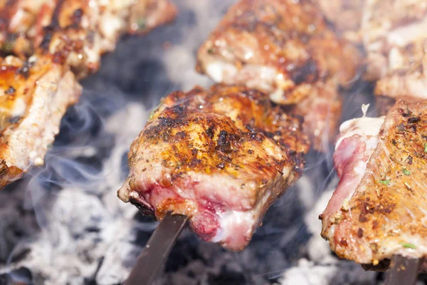 photographed close-up of orange succulent kebabs of pork during their cooking on the fire. Small depth of field.