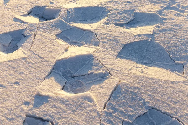 当一个人穿过雪层后 雪层就被打破了 拍摄了冬季雪地里的特写镜头 夕阳西下的时候太阳 田野的一个小深度 — 图库照片