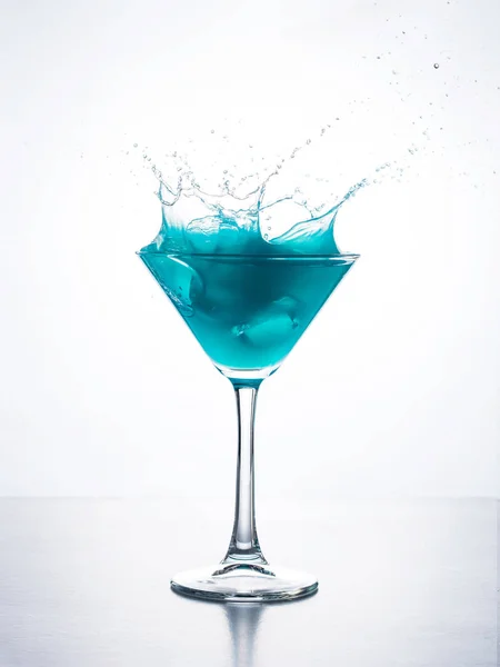 Niebieski Koktajl Szklance Martini Kostką Lodu Rozpryskującą Się Płynie Białym — Zdjęcie stockowe