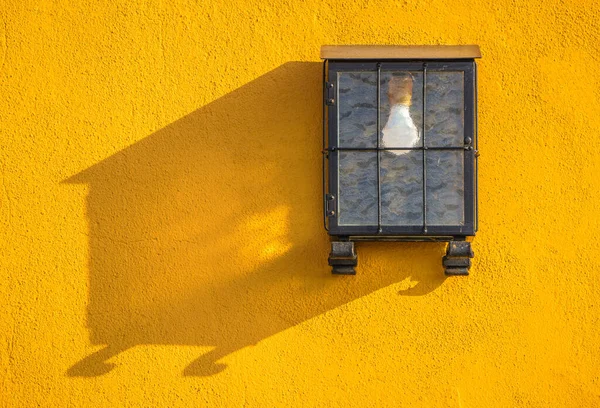 Lámpara Oculta Una Pared Amarilla — Foto de Stock