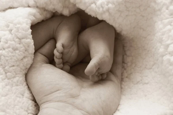 母親の手で赤ちゃんの足 — ストック写真