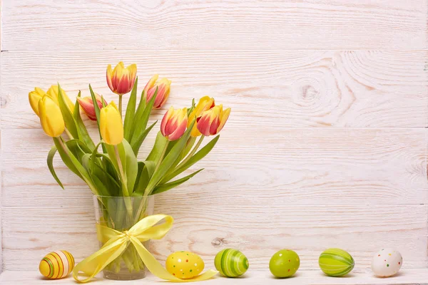 Gekleurde Paaseieren Lente Tulpen Bloemen Vaas Lint Houten Ondergrond Wenskaart — Stockfoto