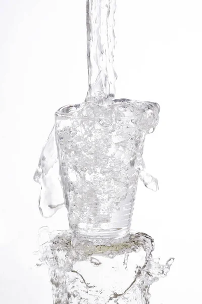 Вода Енергійно Наливає Переповнені Бризки Склянки Білому Тлі — стокове фото