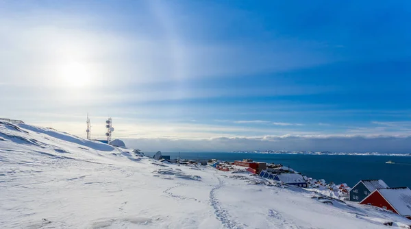 グリーンランドのヌーク市のフィヨルドで家の上に輝く北極の太陽ハロー — ストック写真