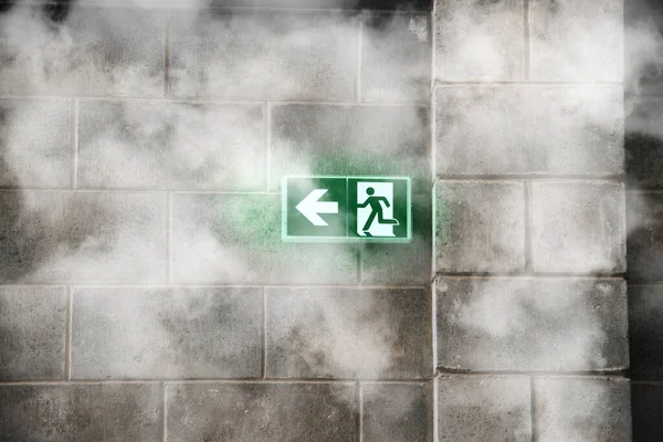 emergency fire exit on the stone wall with fire smoke