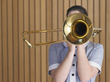 Young teenager practicing with trombone clipart