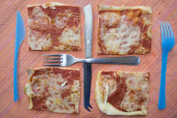 geometric composition made with pieces of pizza and cutlery