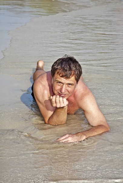 Mannen Baddräkt Ligger Stranden Och Njuter Saltvatten Med Små Vågor — Stockfoto