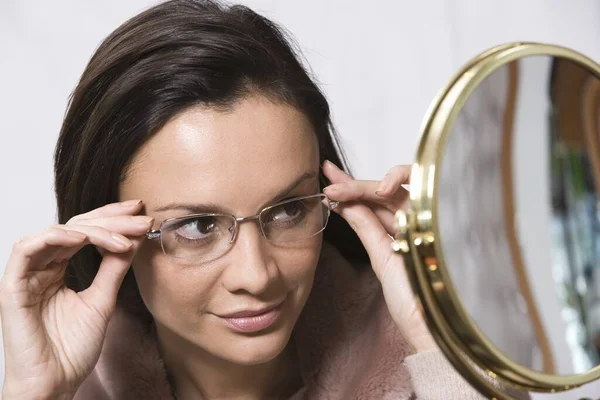 Mujer Hispana Probándose Gafas Mirando Espejo Sobre Fondo Gris — Foto de Stock