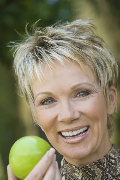 Yeşil Elma Tutan Neşeli Olgun Bir Kadının Yakın Plan Portresi — Stok fotoğraf