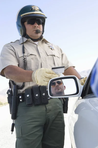 成熟した交通警官車のサイドミラーに反映男の顔とライセンスを保持します — ストック写真
