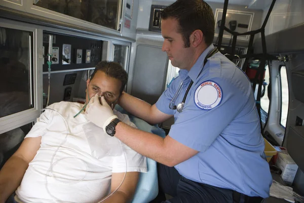 Hombre Emt Profesional Ayudando Hombre Con Máscara Oxígeno Dentro Ambulancia —  Fotos de Stock