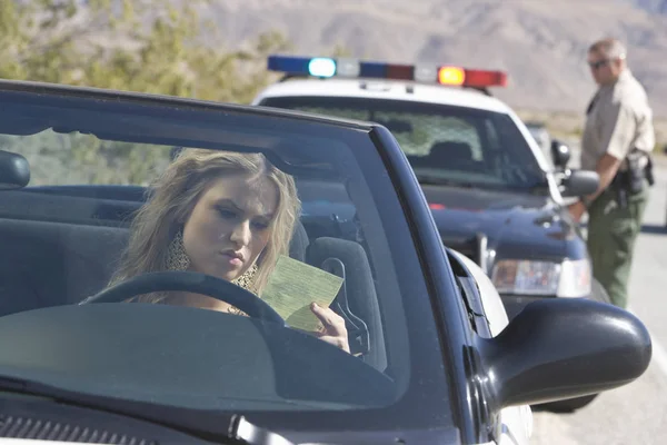 Ung Kvinna Bil Läsa Biljett Med Trafik Polis Bakgrunden — Stockfoto