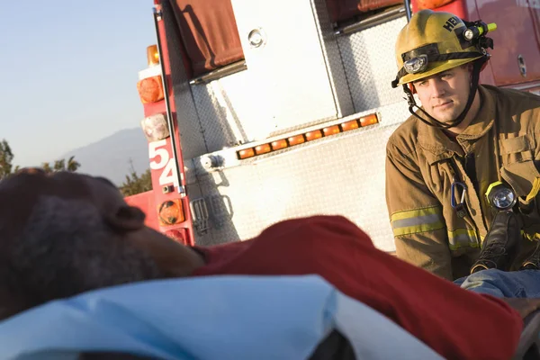 Bombero Mediana Edad Mirando Paciente Con Ambulancia Fondo —  Fotos de Stock