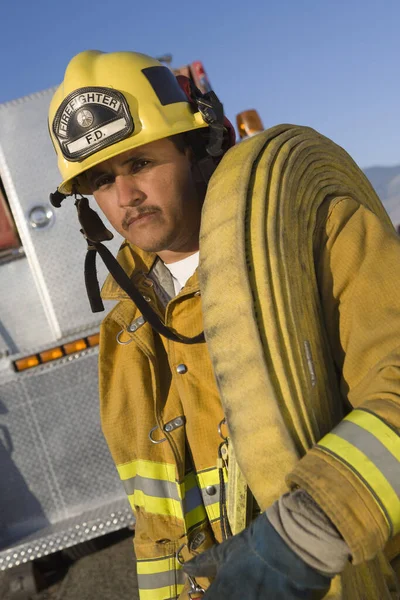 Egy Tűzoltó Portréja Aki Tűzoltó Tömlőt Hord Vállán — Stock Fotó