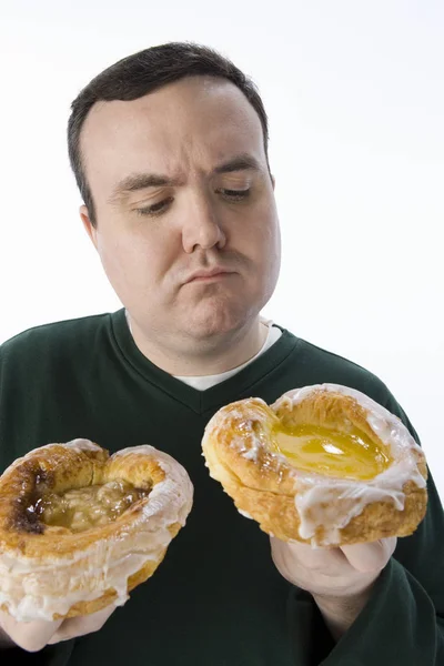 Чоловік Середнього Віку Робить Вибір Між Двома Пончиками Ізольованими Білому — стокове фото